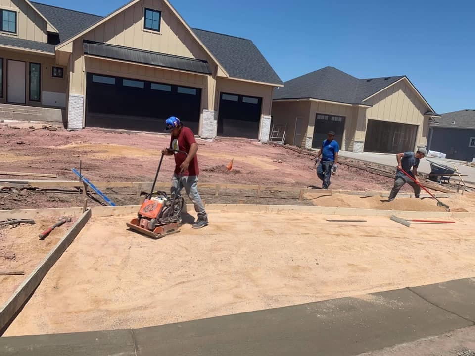 Our crew compacting the graded base in front of a garage before the pour