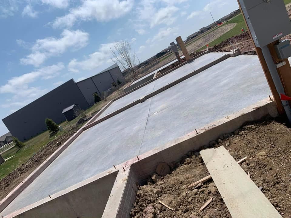 A finished slab with wood form boards and a scored straight control joint