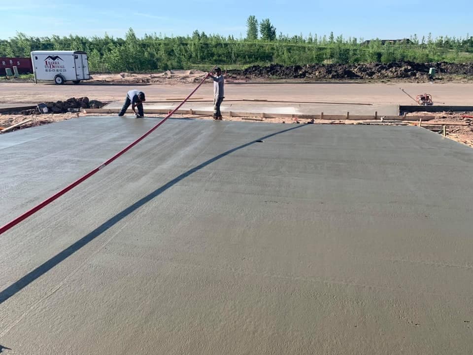 Our crew pulling a screed across a large freshly placed slab