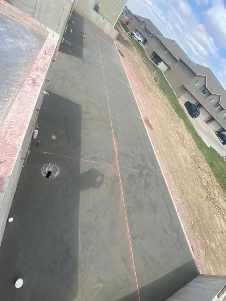 A finished concrete apron with a center floor drain