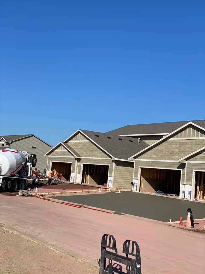 A concrete truck and our crew placing a fresh driveway apron in front of a row of new garage units