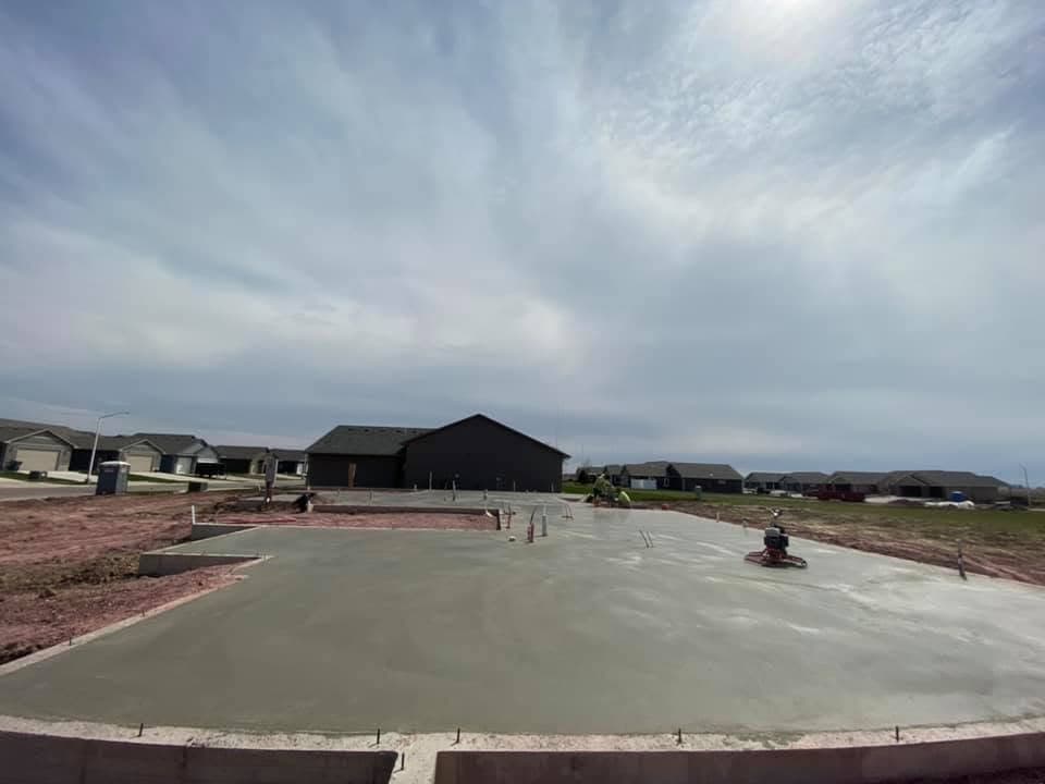 A ride-on power trowel bringing a fresh slab to a hard, dense finish