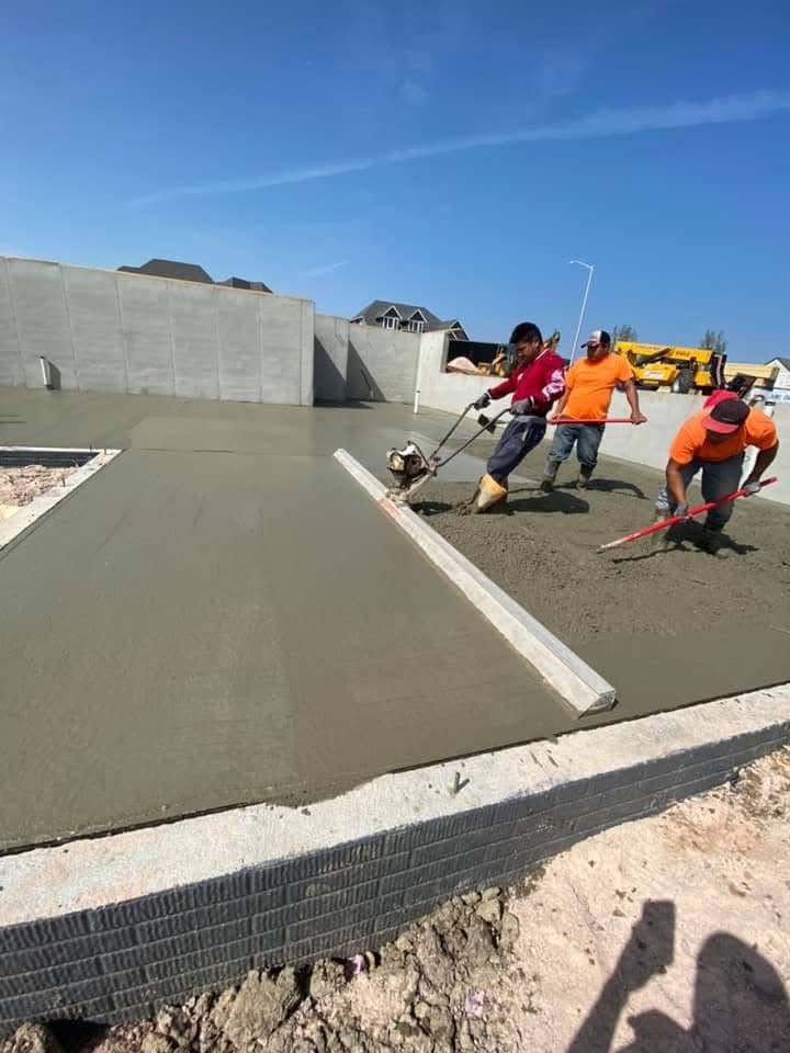 Our crew floating and finishing the surface of a large fresh slab against a poured foundation wall