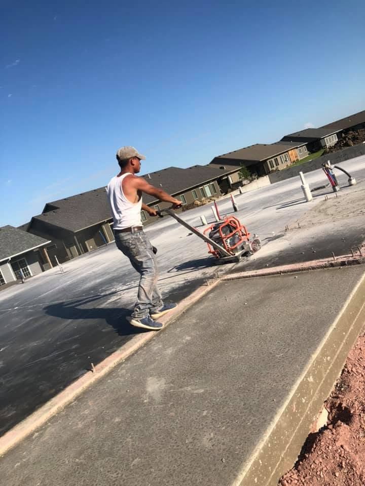 A worker saw-cutting a control joint into a cured slab