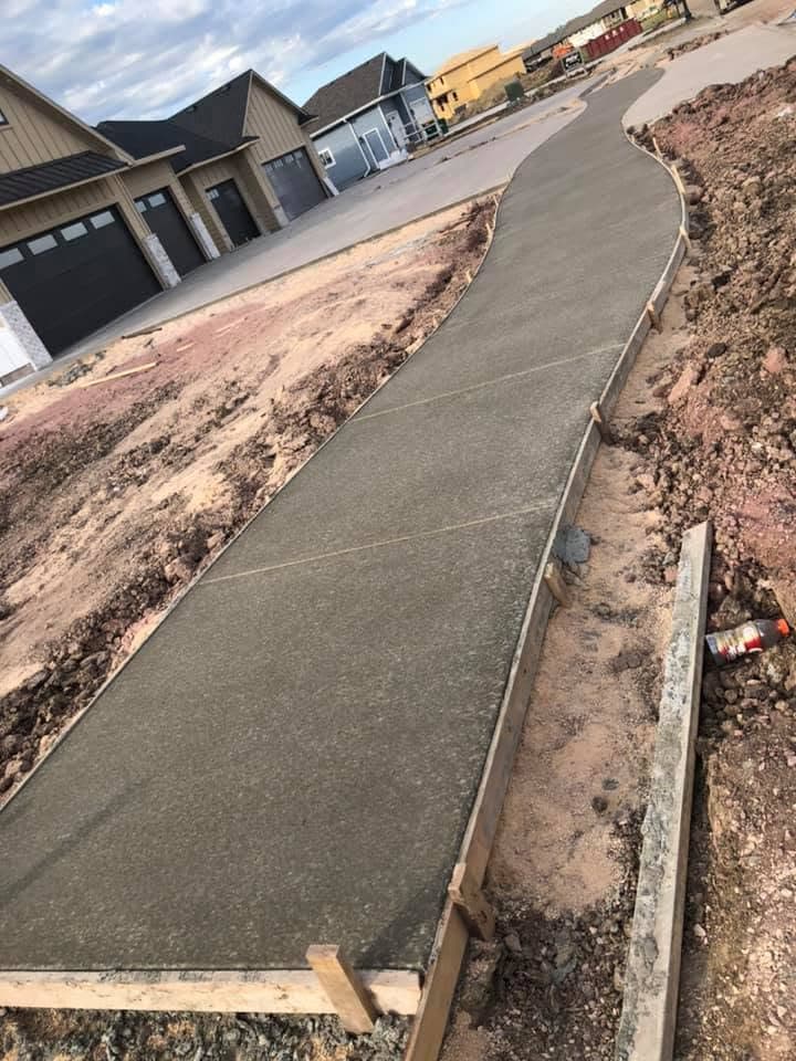 A curved concrete walkway following the grade of a landscaped slope