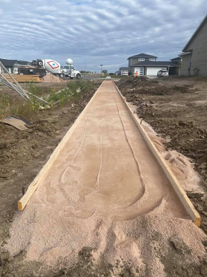 A freshly poured Dakota walkway, still rough off the screed, wood forms along both edges